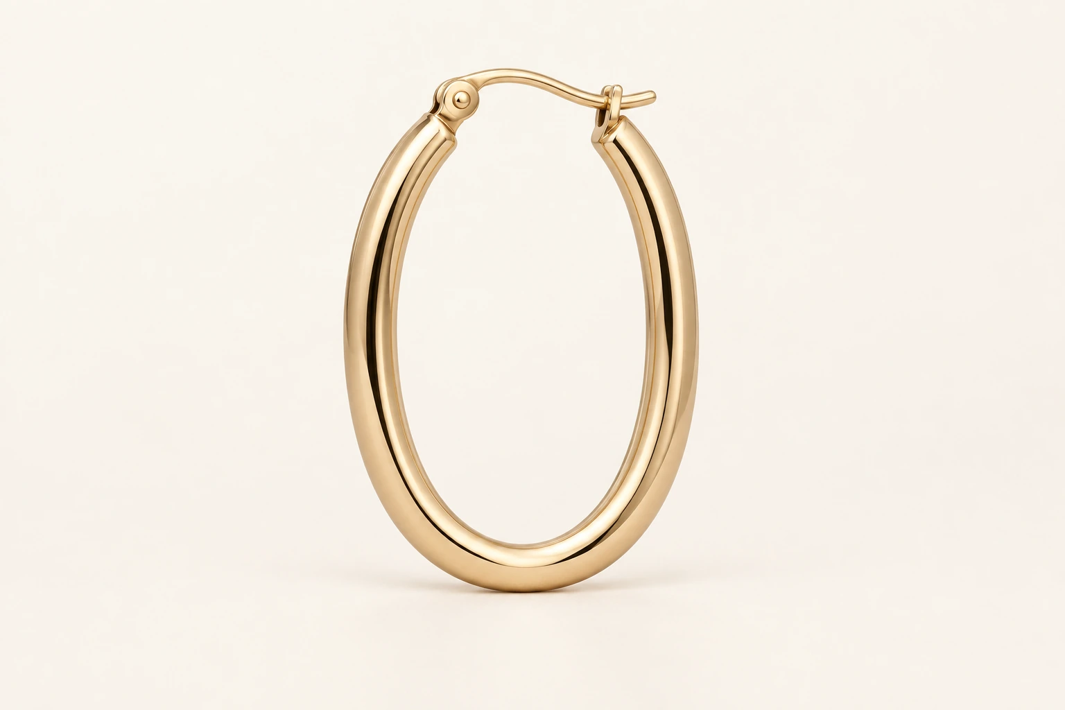 Close-up of a polished gold-tone oval hoop earring