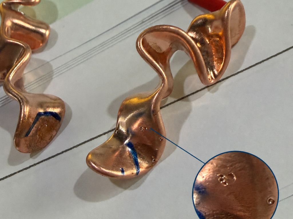 Close-up of an earring casting defect showing small pinholes on the metal surface, which can affect polishing, plating quality and final jewelry appearance.